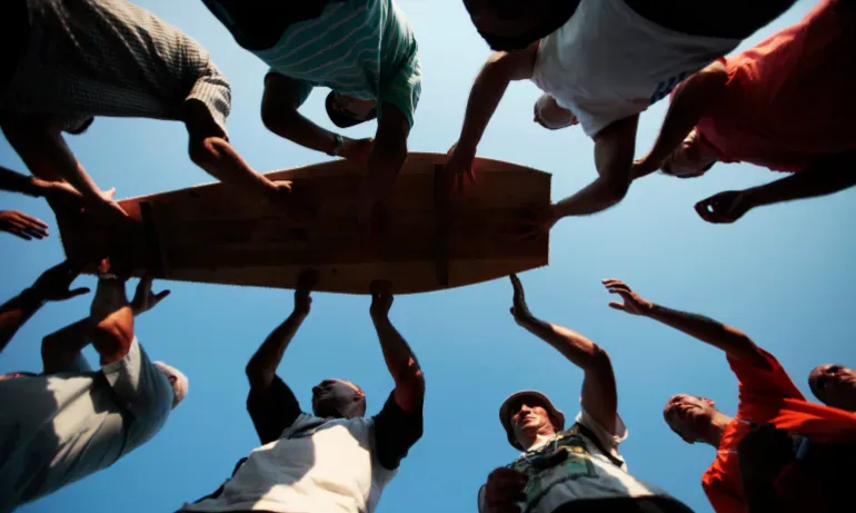 Men pass a coffin